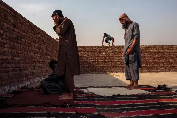 Pashtun football players from Quetta pray during the All-Pakistan Don Bosco Football Tournament. Image by Monika Bulaj. Afghanistan, 2018.