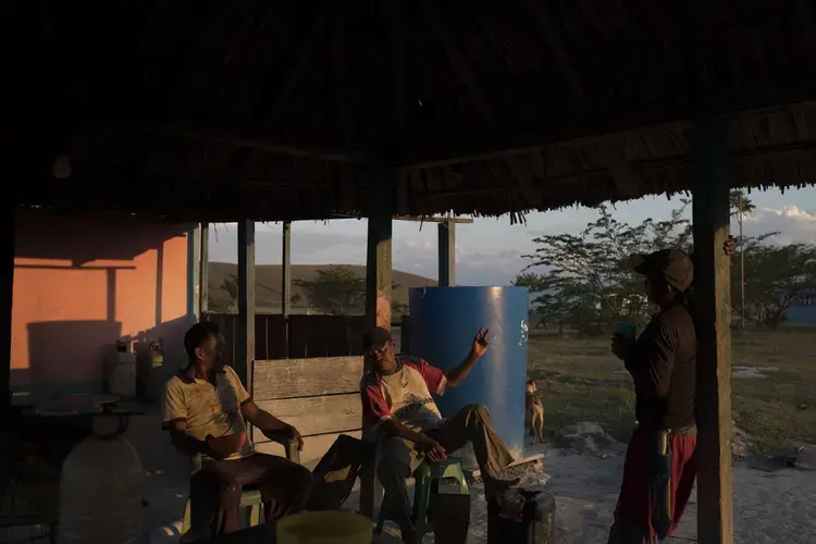 A group of men chatting at the Campo Alegre community after returning from the conuco. Image by Fabiola Ferrero. Venezuela, 2020.