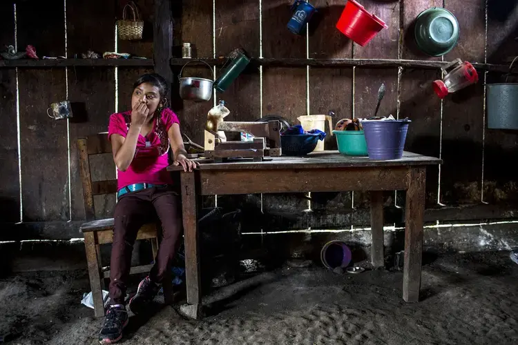 Candelaria López, 15, at home in Yalambojoch, stays at home to help raise her siblings. She no longer goes to school because her family can’t afford to pay the $60 school fee. Image by Simone Dalmasso / The Arizona Daily Star. Guatemala, 2019.<br />
