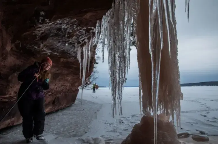 Rene Wagenaar, of Merrill, Wisconsin, examines ice formations during a tour of ice caves on the shore of Lake Superior in the Red Cliff reservation in Wisconsin on Feb. 15, 2020. Image by Zbigniew Bzdak/The Chicago Tribune. United States, 2020.