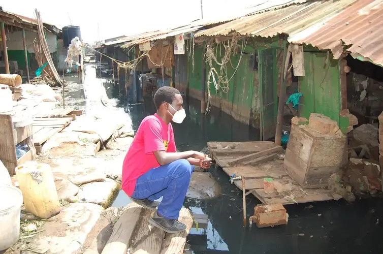 Noah Omuya looking at the flooded shop that belonged to Sarah Kaine before it was taken over by the water. Image courtesy of Noah Omuya. Uganda, 2020.