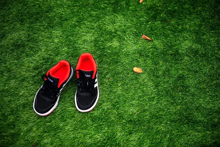 Sneakers belonging to David Crichton in the entrance to his sensory garden in the backyard of his home in Possilpark. Image by Michael Santiago. United Kingdom, 2019.