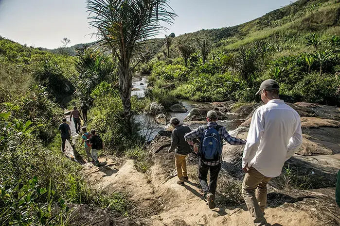 A PIVOT team heads to a remote village on a rugged footpath, across many streams and through muddy gullies—the only way to reach most villages in Madagascar. Image by Rijasolo. Madagascar, 2019.