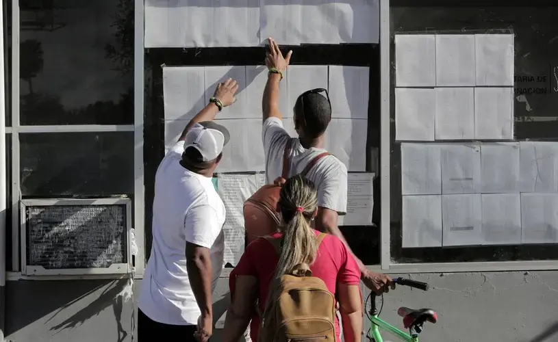Cuban migrants check their status on the list posted by the entrance to the Gateway International Bridge in Matamoros, Mexico. Image by Jose A. Iglesias. Mexico, 2019.