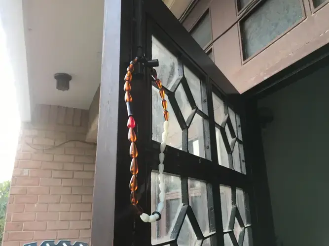 CycleBeads hang from a window in Delhi. Image by Hannah Harris Green/The World. India, 2019.