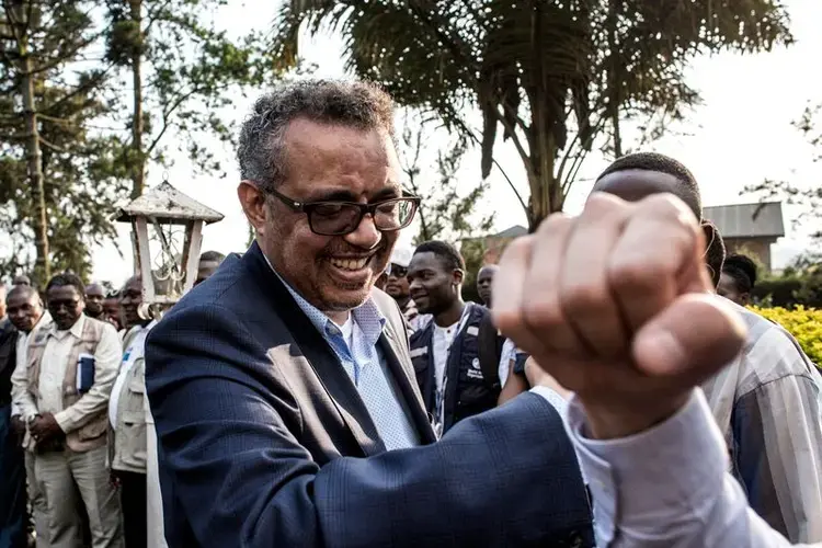 Tedros greets colleagues in Butembo with what has become the unofficial salutation for Ebola responders. Image by John Wessels. Democratic Republic of Congo, 2019.<br />