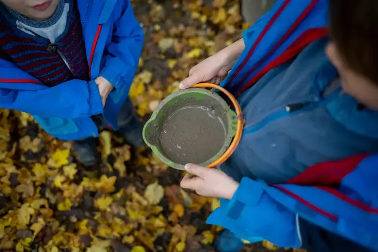 Mud is a major component and commodity for children attending forest preschools in Germany. For children with some imagination, it serves many functions. For parents, it means not being worried about doing laundry. Image by Ryan Delaney. Germany, 2020.