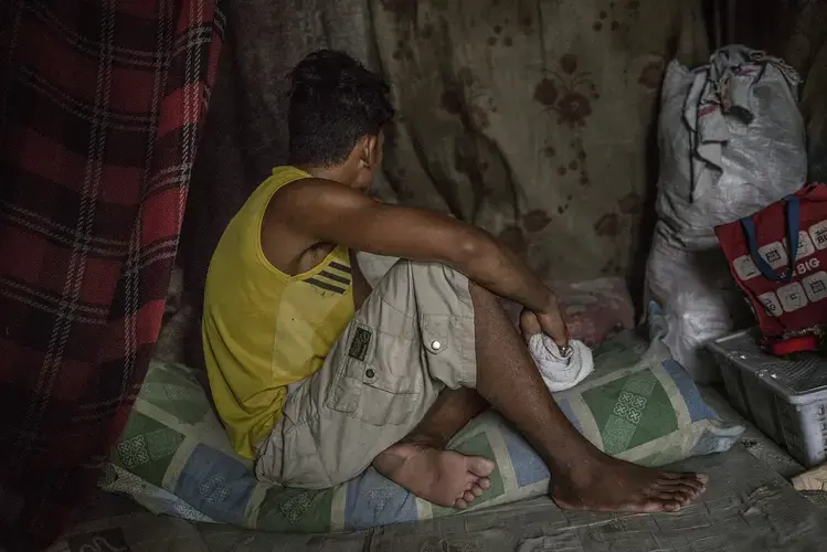 Saldi, 20, sits in the shack he constructed from plastic sheeting and scrap wood in Navotas. He began using methamphetamines to stay awake through his long shifts at the Navotas Fish Port. It’s a common route to addiction in Market 3, where people sometimes need to work 36-hour shifts to escape grinding poverty. Saldi says that he has lost 14 friends to unidentified assassins. And as a former methampetamine user himself, he worries that he may be next on the hit lists of drug users composed by local mayors in the slums. Image by James Whitlow Delano. Philippines, 2017.