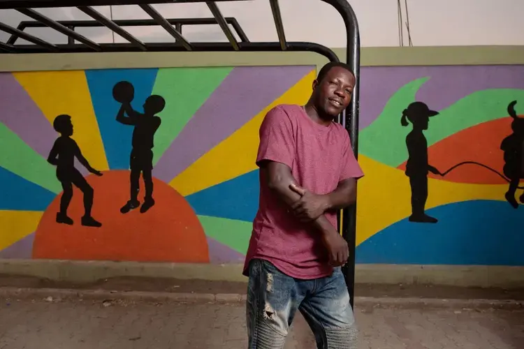 Community leader Evenson Louis poses for a photo in the recently completed public plaza in the Canaan 1 neighborhood. Louis and other leaders worked with the American Red Cross to design the park. 'It's the beginning of the future for this area,' says Louis. Image by Allison Shelley. Haiti, 2019.