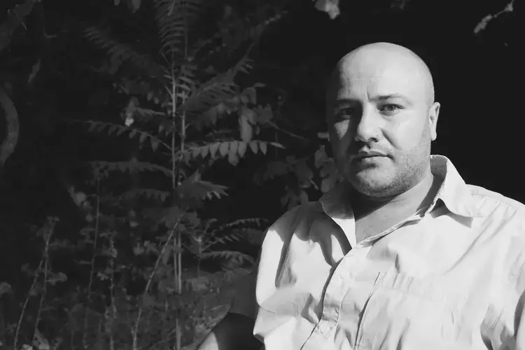 Sa'id Ali, a Syrian journalist based in Amman, looks at the camera in Amman's Zahran neighborhood. Image by Aman Madan. Jordan, 2017. 