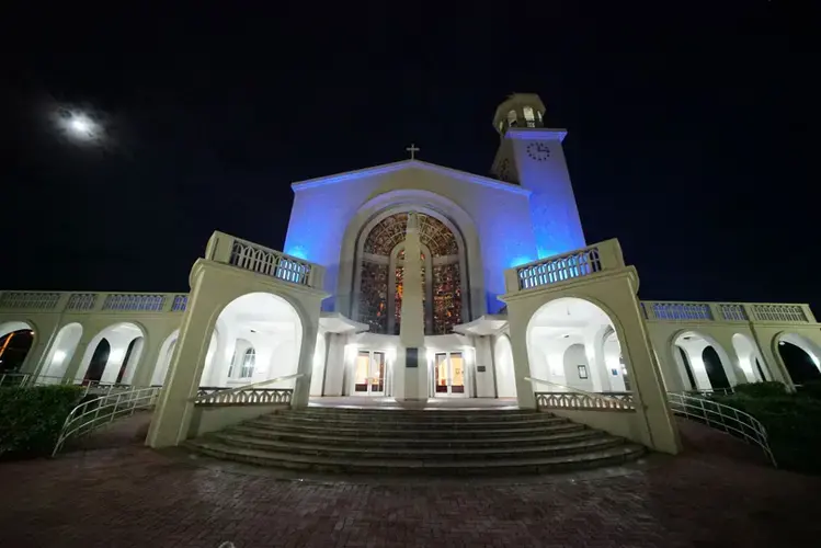 The moon sets over the Dulce Nombre de Maria Cathedral Basilica in Hagatña, Guam before a 5:45 a.m. Chamorro Sunday morning Mass. Image by Cory Lum. Guam, 2017.