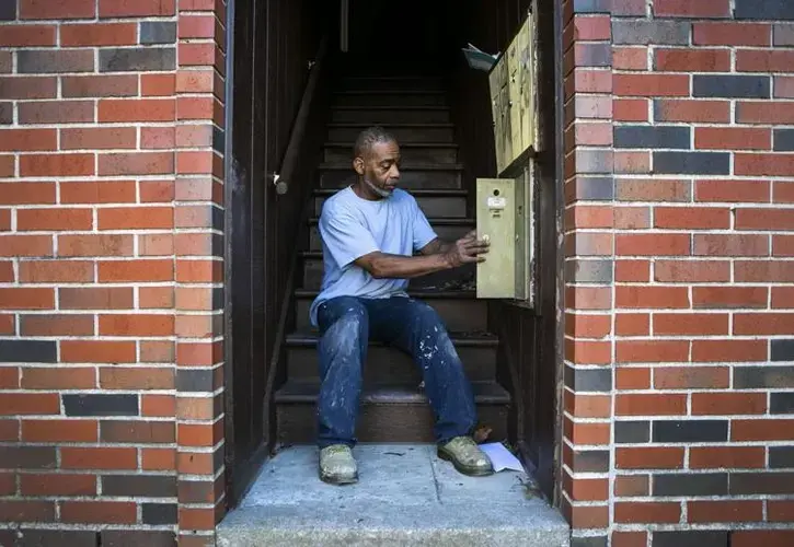 Charles Roberts fixes a mailbox for an apartment he is doing maintenance on to prepare for tenants to move into at the Reserve at Heritage Apartments in the Ville on Tuesday, Dec. 22, 2020. Roberts has been doing maintenance work for about 30 years and previously helped maintain the Preservation Square apartments in the Carr Square neighborhood. He used to work with Valerie Nichols who worked and lived in the apartments at Preservation Square and made the living conditions of the members of her community there a priority. Photo by Cheyenne Boone. United States, 2020.