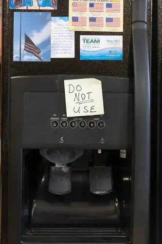 Arlin and Mary Lou Karnopp have a reminder on their refrigerator's water dispenser not to use it. Image by Mark Hoffman. United States, 2019.
