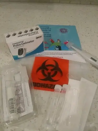 The trial sent Melba home with equipment including an oral thermometer to monitor her body temperature, an oximeter to record her pulse rate and blood oxygen level, and a ruler to measure any injection site redness or swelling. Image courtesy of North Carolina Health News. United States, 2020.<br />