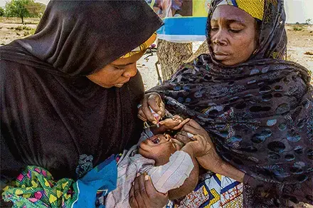 Health workers give polio drops to children by the roadside in Monguno as they escape from inaccessible areas. Image by Andrew Esiebo/ Associated Press.