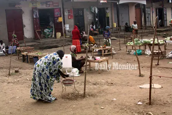 An elderly woman washes hands at Kazingo trading centre in Bukuuku sub county, Kabarole District. Image by Felix Basiime. Uganda, undated.