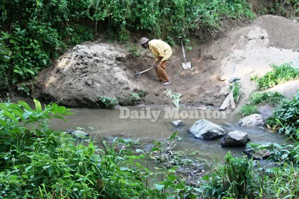 A man in Karangura sub county, Kabarole District extracts sand from river Mpanga. The activity leaves water contaminated. Image by Felix Basiime. Uganda, undated.
