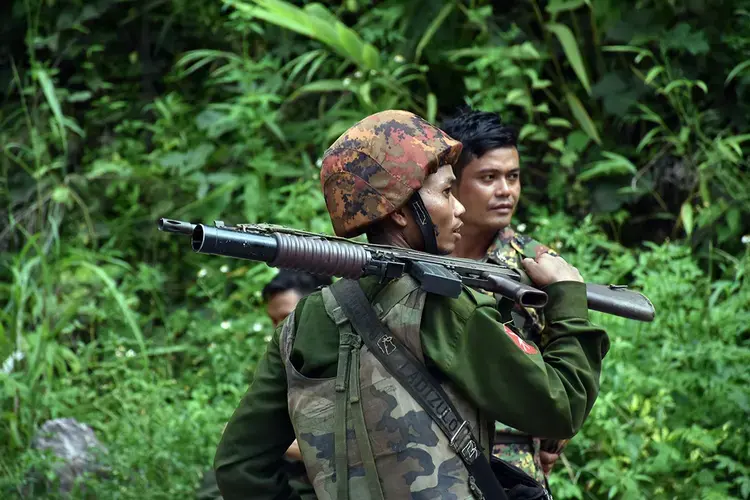 Tatmadaw troops stand guard at the Goktwin bridge as it undergoes repairs after an attack by an armed ethnic organisation in the region in August 2019. Image by Steve Tickner. Myanmar, 2019.