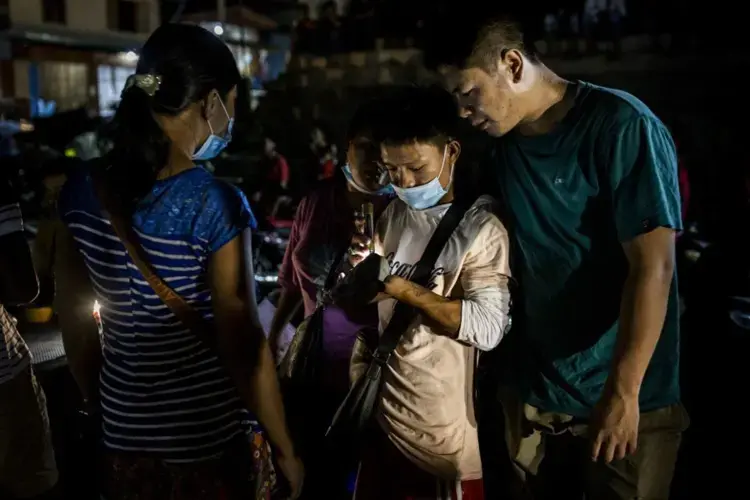 A buyer inspects jade being sold in a market in Hpakant. Image by Hkun Lat. Myanmar, 2020.<br />
