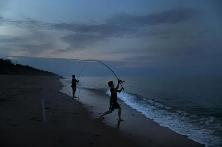 Boys fished at night on Nauset Light Beach. Image by John Tlumacki. United States, 2019.