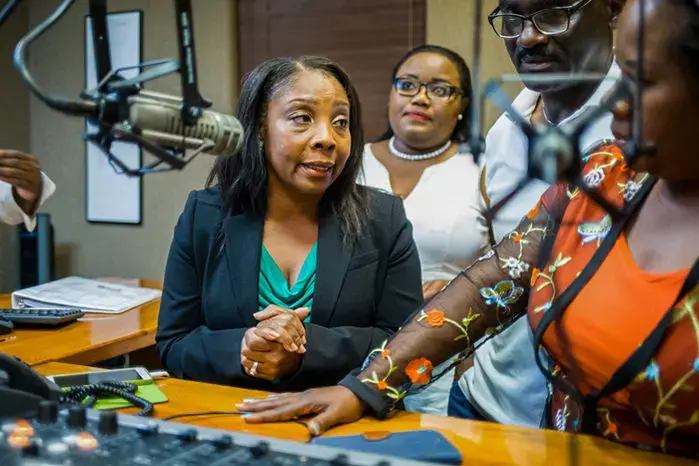 Suzie Armas (left) speaks in Creole on WLQY-AM in Miami to encourage Haitian immigrants to come to her clinic for HIV testing and care. Image by Misha Friedman. United States, 2018.