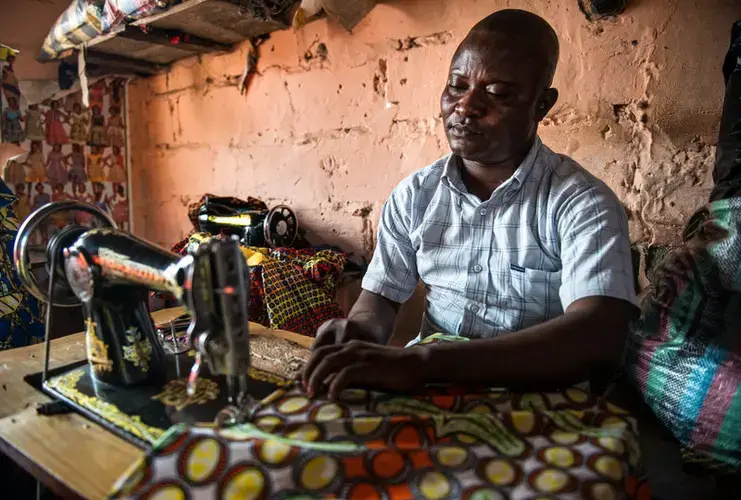Gaby Ngabu Kasongo also has konzo. But his life has improved since he found a job as a tailor. Image by Neil Brandvold. DRC, 2017.
