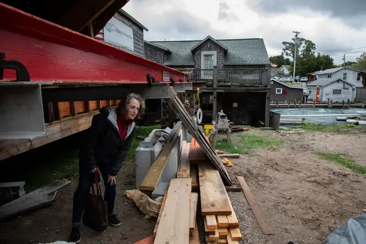 Amanda Holmes, executive director of the Fishtown Preservation Society, looks at shanties being raised in Leland, Michigan, on Oct. 1, 2020. The Fishtown Preservation Society is a nonprofit that is working to save this historic enclave of 19th-century Lake Michigan shanties. Image by Zbigniew Bzdak/Chicago Tribune. United States, 2020.