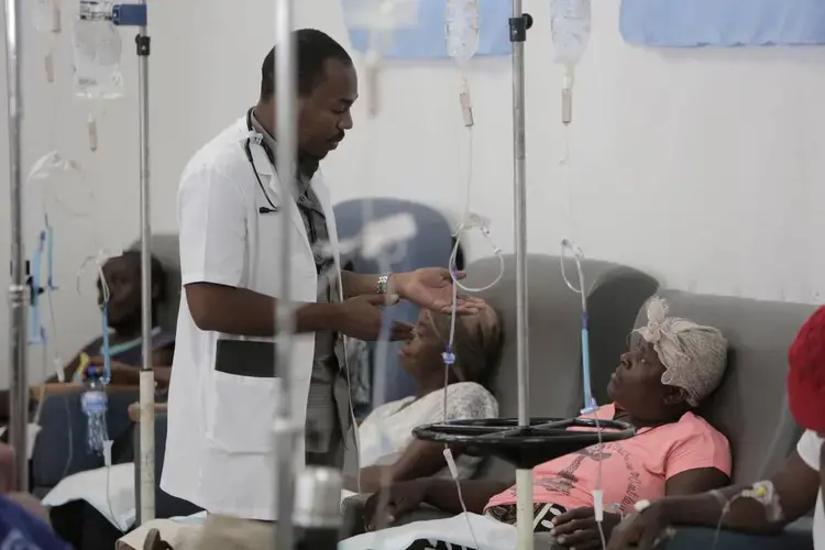 A physician talks to Paula Paul as she gets hydration before chemotherapy at the University Hospital of Mirebalais in central Haiti. Image by José A. Iglesias. Haiti, 2018.