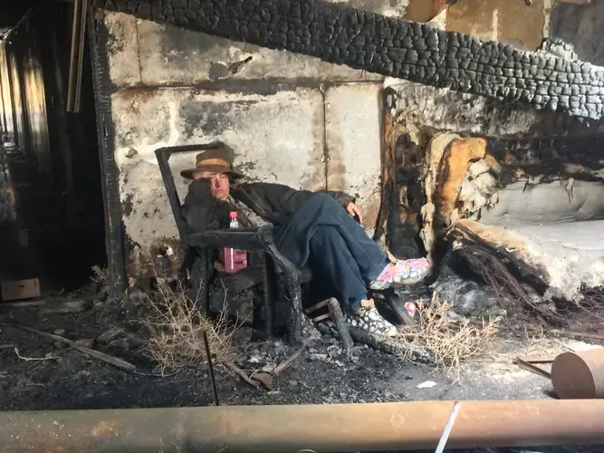 Byron Seeley poses for a photo inside the burned-out barracks of Western Nuclear. Image by Ben Mauk. United States, 2017.