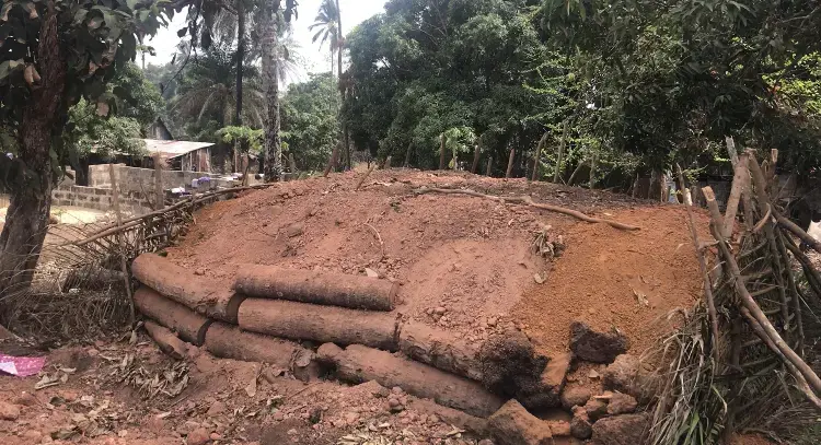 Smothering wood in a process that will create approximately 26,400 pounds of charcoal. Image by Kadia Goba. Sierra Leone, 2018.