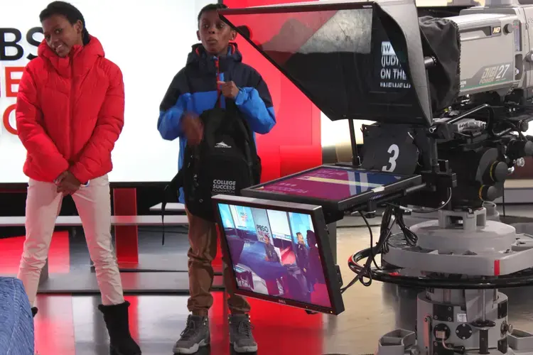 In the PBS NewsHour studio, the next generation of journalists try their hand at reading from a teleprompter. Image by Kim Pate. United States, 2018.