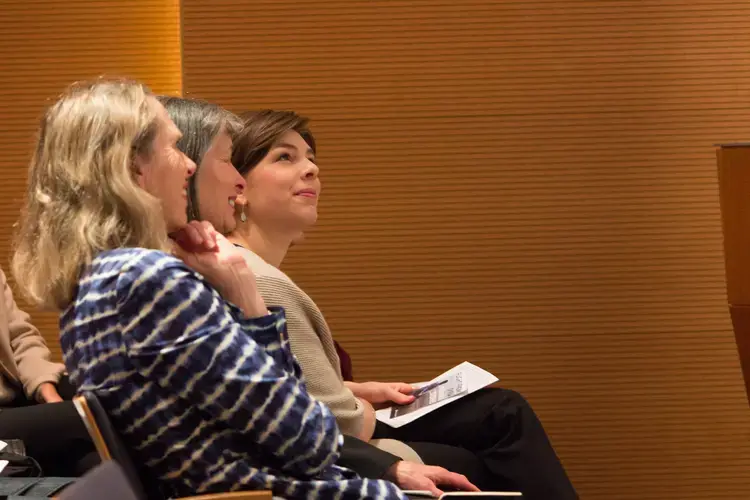 Amy Russo, Hunter College Student Fellow (right), and other audience members view photos of reporting from the field. Image by Lauren Shepherd. United States, 2017.