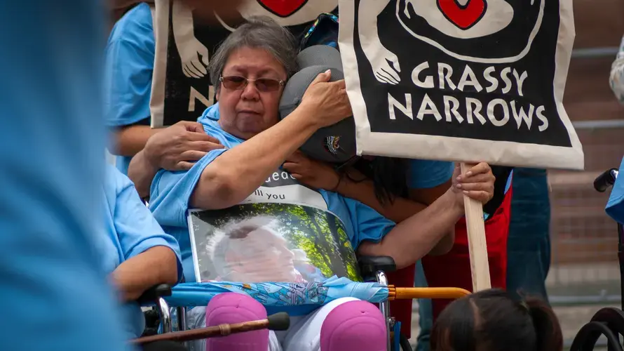 Community members embrace in an intimate moment following tales of pain from other community members. Image by Shelby Gilson. Canada, 2019.