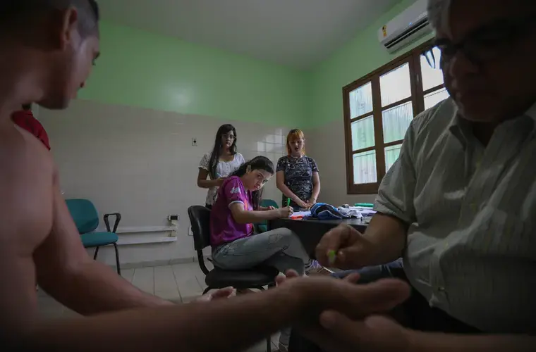 Center left to right: Physiotherapy student Luciana Rodrigues, nursing student Nadime Fraiha do Rêgo and pharmaceutical student Angélica Gobbo—all members of the Laboratory of Dermatology-Immunology—take notes as Dr. Claudio Salgado performs a monofilament test on a male patient. This procedure, which assesses a person’s loss of sensation, is commonly the first step of a leprosy examination. Image by Anton L. Delgado. Brazil, 2020.