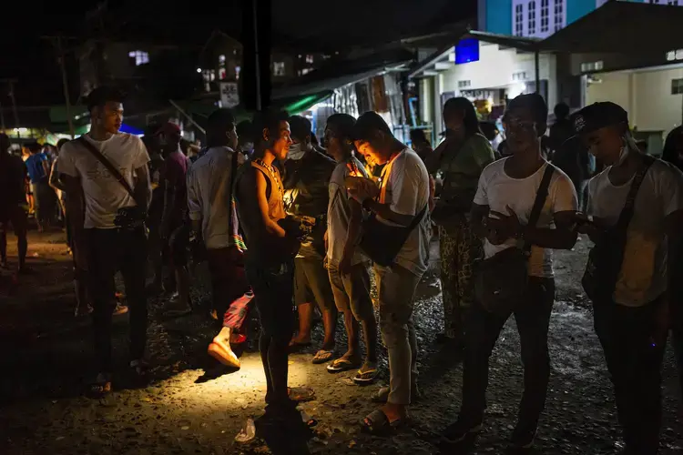 Jade buyers use flashlights to determine the value of stones at Hpakant Township’s Lunghkang jade market on July 15, 2020. Image by Hkun Lat/Frontier. Myanmar, 2020.