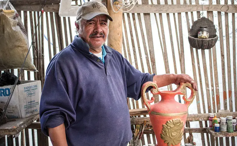 Juan Molina at his pottery workshop in La Victoria. Molina stopped producing roof tiles when his family got sick; the family now decorates pre-made ceramic animals and vases with paints and metallic enamels. Image by Yolanda Escobar. Ecuador, 2016.