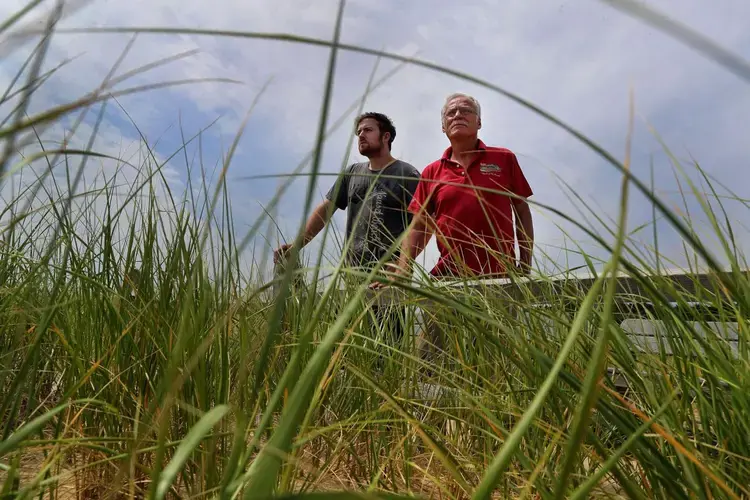 Liam Ohman (left) and his father, John, returned to the site of their restaurant for the first time since it was demolished. Image by John Tlumacki. United States, 2019.