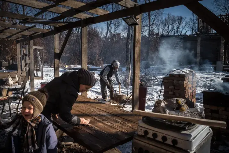 Outside Blagoveshchensk. Fedor, Ksenia and Andrey Shvalov at their homestead. The family erected buildings and dug a well but found little infrastructure to connect to, and they lacked other support from the government. Image by Sergey Ponomarev. Russia, 2020.</p>
<p>