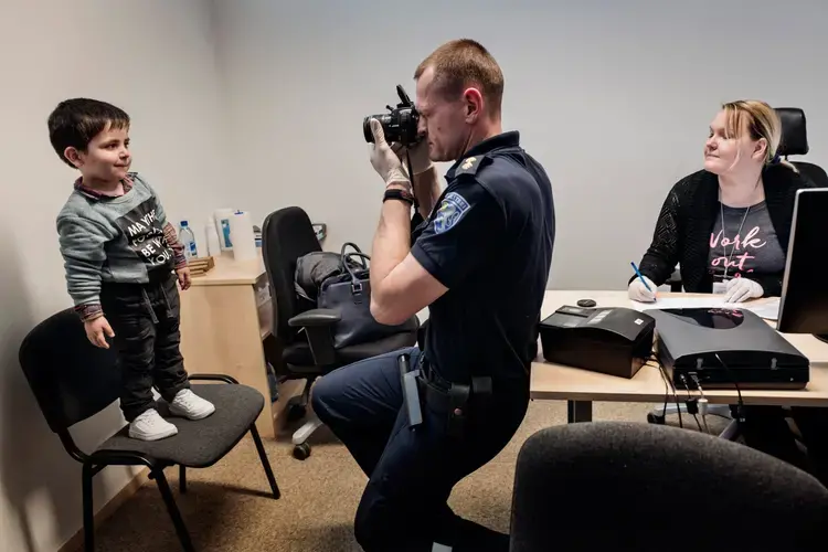 Syrian refugee Wael Abzali is fingerprinted and photographed by Estonian border officials in the airport in Talinn upon arrival in Estonia. Image by Lynsey Addario. Estonia, 2017.