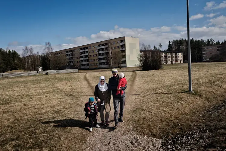 Syrian refugees Taimaa Abzali and her husband Muhanned Abzali, and their six month old daughter, Heln, and son Wael, walk near their apartment complex on their first full day in Estonia. Image by Lynsey Addario. Estonia, 2017. 