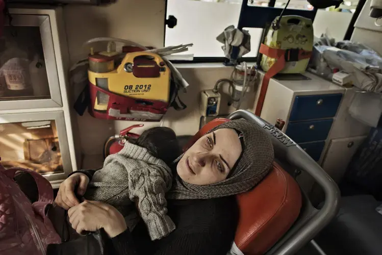 Taimaa and her daughter, Heln, ride in a Greek ambulence to the hospital in Athens as Heln, who was diagnosed with an acute bronchial infection before they left Thessaloniki, became sicker during their journey to Athens. Image by Lynsey Addario. Greece, 2017.