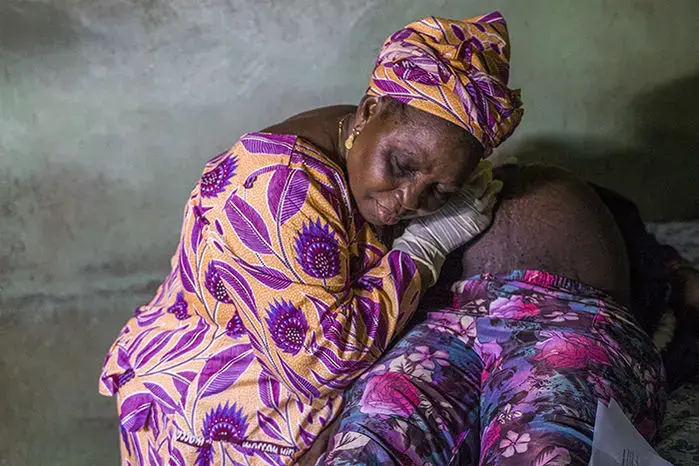 Mama Metta, a traditional birth attendant in Lagos, Nigeria, listens to a woman’s belly with a Pinard horn. Image by Misha Friedman. Nigeria, 2018. 