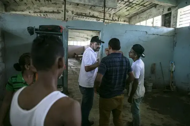 Padre Ramon, the man who first opened Todo por Ellos, speaks with migrants at the shelter. Image by Jose Cabezas. Mexico, 2018.