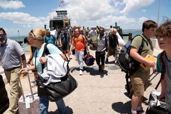 Legal teams, service members, base workers, journalists and others shuttle to and from Guantánamo Bay on a regular basis. The logistical challenges will increase when the trial of the alleged Sept. 11 plotters begins. Image by Doug Mills / The New York Times. United States, undated.