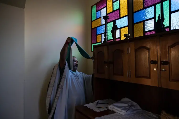 Father Amaro Lopes prepares to celebrate a mass in a chapel at the bishop’s house in Altamira. Image by Spenser Heaps. Brazil, 2019.