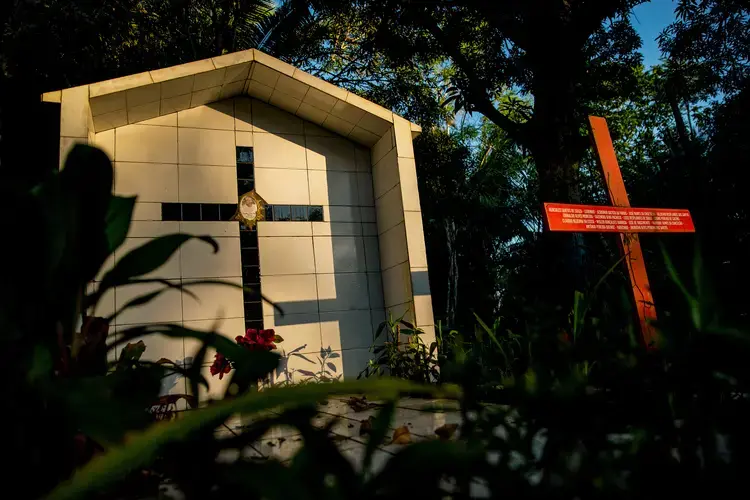 The grave of Sister Dorothy Stang is pictured at sunset. At right is a cross bearing the names of other people killed in land conflicts in Anapu. Image by Spenser Heaps. Brazil, 2019.