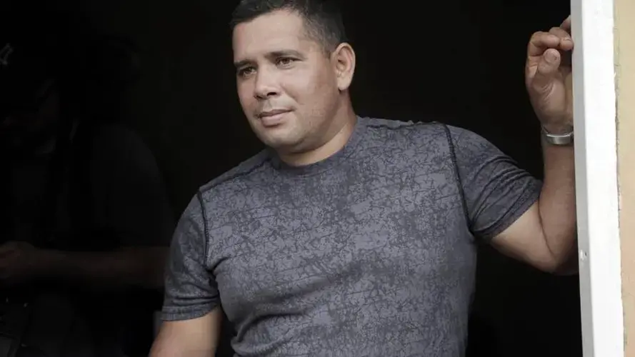 Yoendry Batista stands in the front door of a house he rents with his wife Yudenny Sao Labrada in Panama City, Panama. Image by Jose A. Iglesias. Panama, 2017.