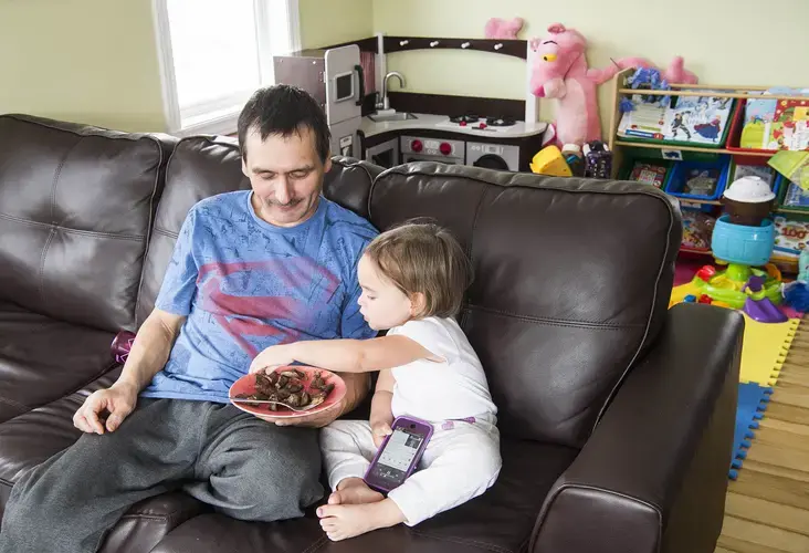 Karl Michelin eats seal liver and onions at home in Rigolet with his two-year old daughter Josephine. Michelin harvests about 12 seals a year that feed his family and Inuit elders in the community. Image by Michael Seamans / The Weather Channel. Canada, 2019.