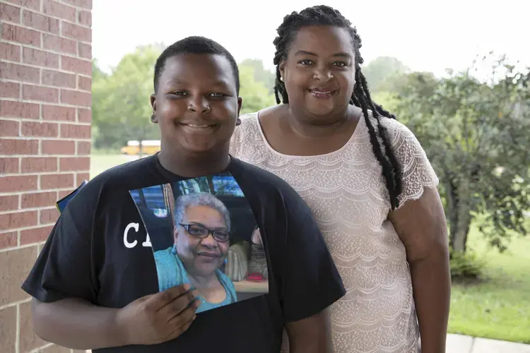 Karlton Jackson (left), age 10, holds a photo of his late grandmother, Carol Faye Doby, as he stands with his mother Shenika Jackson (right) on Friday, September 25, 2020 in Bolton, MS. Doby, of Stonewall, passed away from complications of COVID-19 earlier this year. Image by Sarah Warnock/MCIR. United States, 2020.<br />