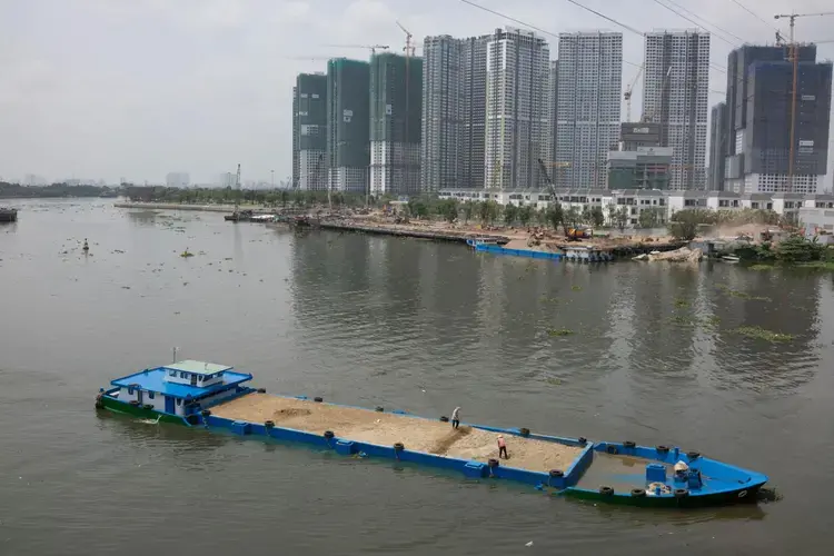 Ho Chi Minh City, formerly known as Saigon, is Vietnam's economic center. Much of the sand being dredged and pumped up from the Mekong goes towards construction here and in other cities in southern Vietnam. But some has been exported to Singapore, which requires large amounts of sand for land reclamation projects. Image by Sim Chi Yin. Vietnam, 2017.</p>
<p>